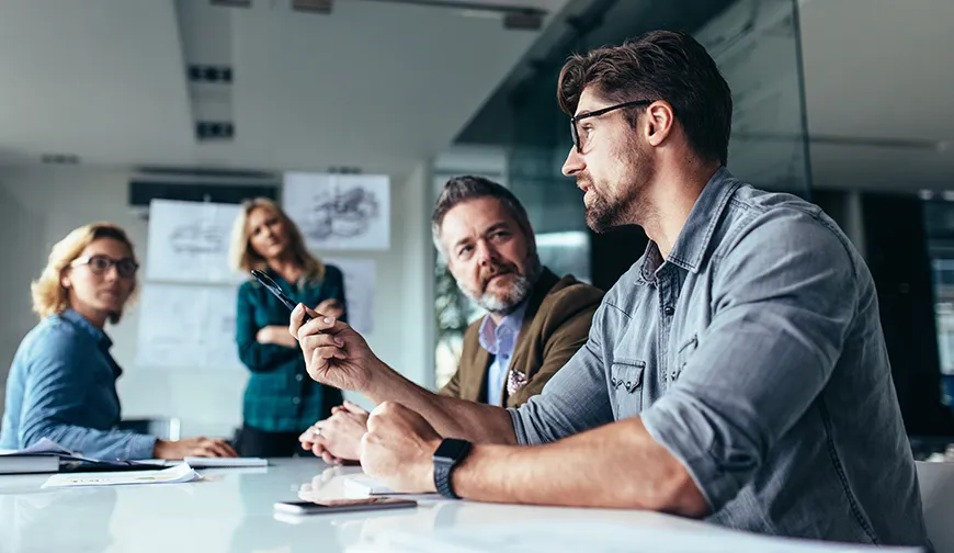 A business meeting where one of the people gives a talk while the others listen