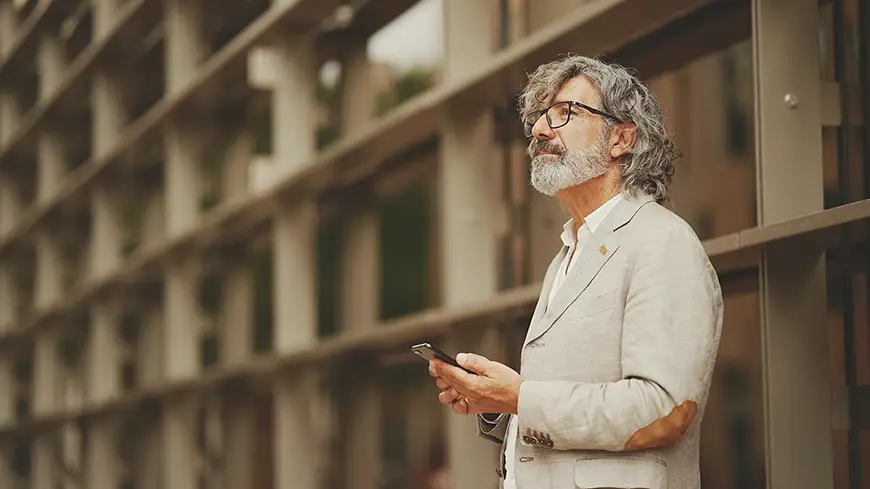 A stoic mature man in business casualwear looking to the sky