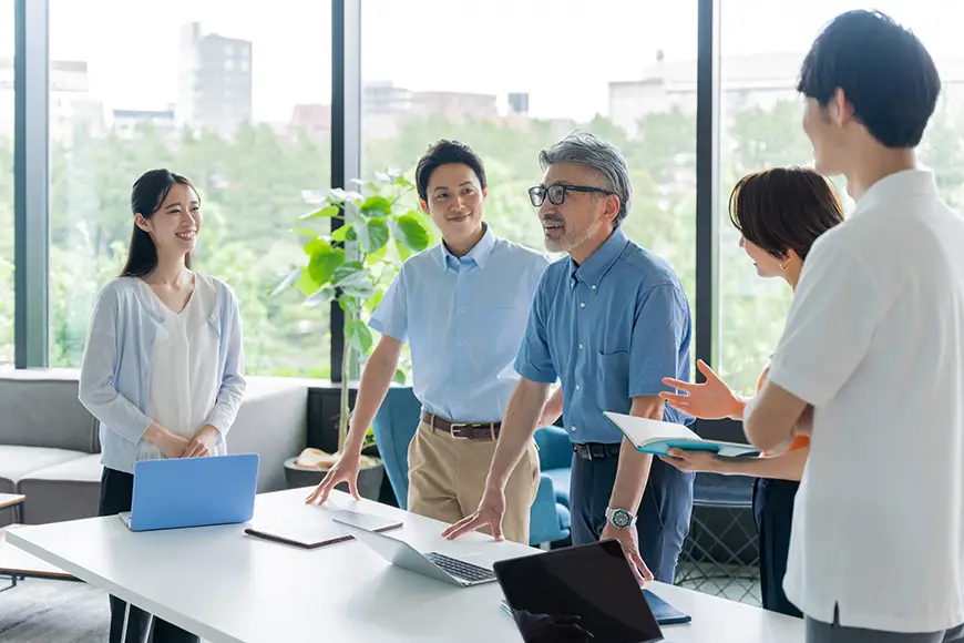 A leader stands in the center of his team conveying his vision for the future