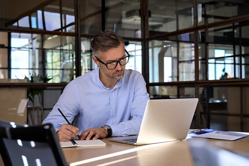 A male executive uses his laptop to study for his MBA program