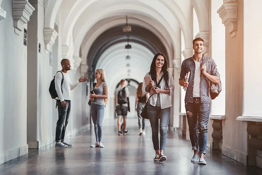 A Group of students walk into the university hall and chat