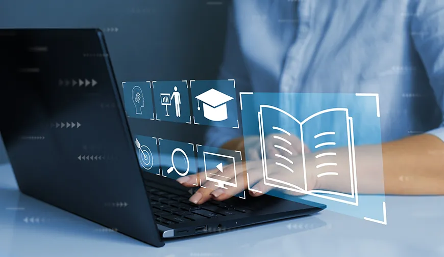 A person working on a laptop while the laptop projects several holographic images: a graduation hat, a person pointing at a graph, a monitor, a magnifying glass, an arrow that hit the mark, and a big book.