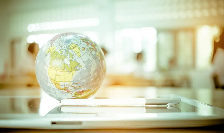 Earth globe on a tablet with a bright classroom in the background