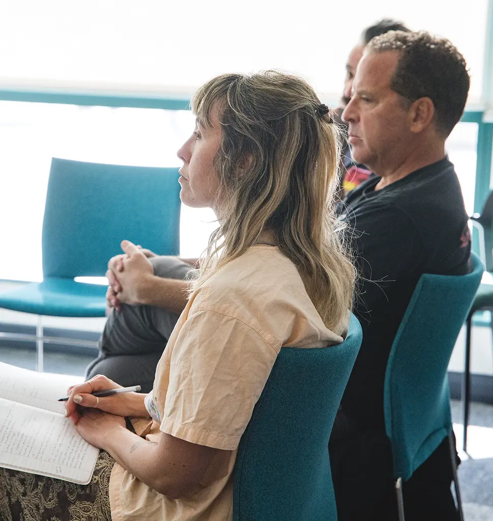 Two men and a woman smiling and having a conversation at a a networking event desktop